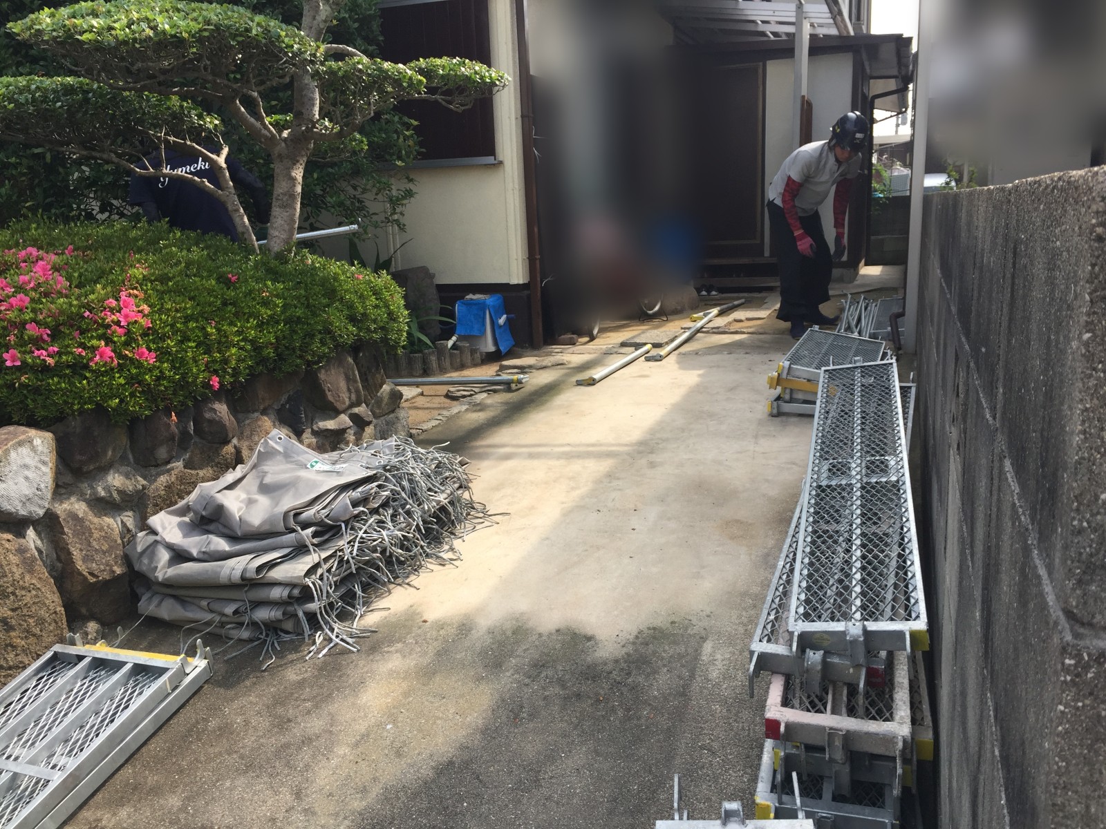 倉敷市の住宅で屋根カバー工法に使用する足場資材を玄関までの通路に搬入
