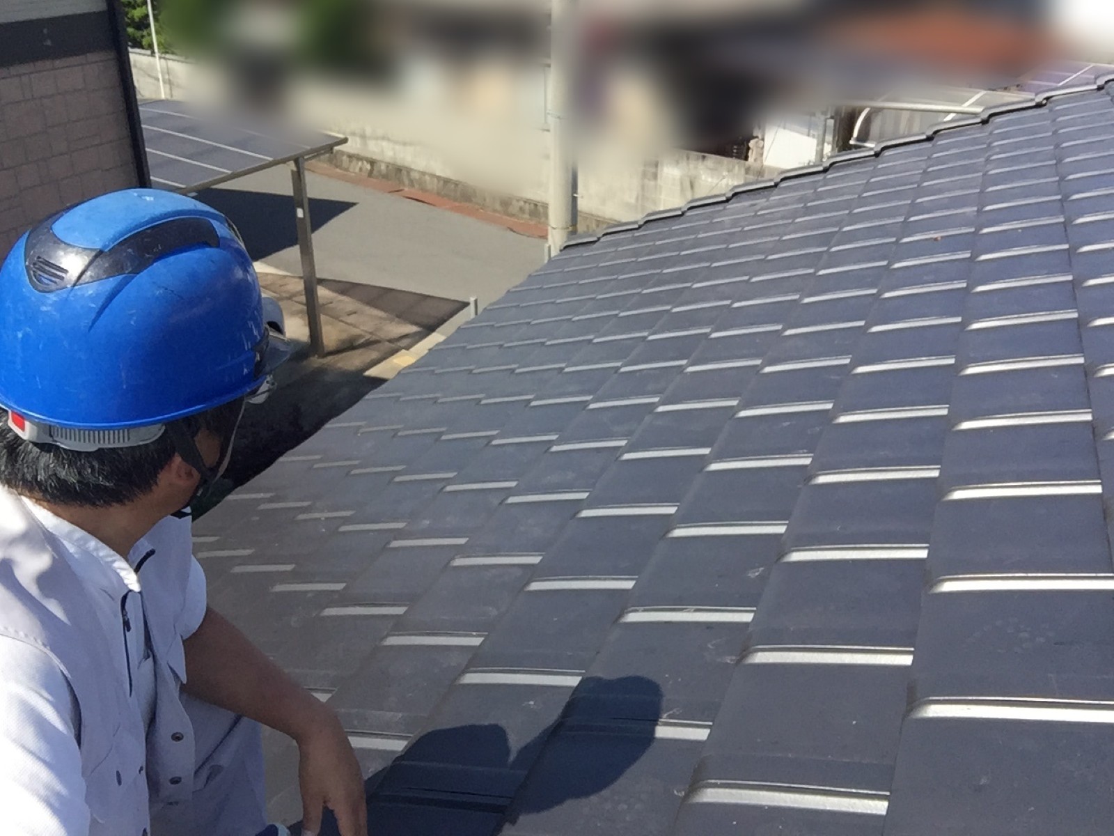 岡山市南区の住宅で葺き替え後の平板瓦の屋根を確かめる職人