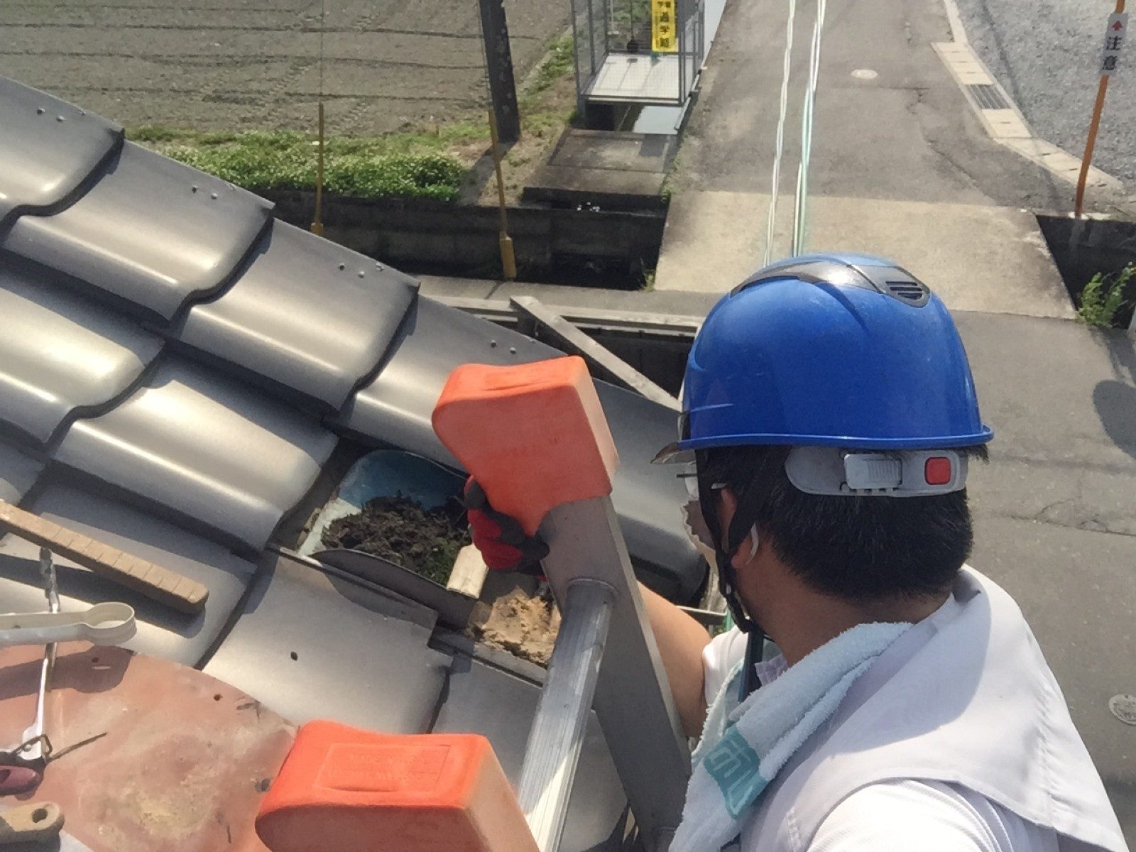 上合の中から取り出した黒っぽい土を容器に集める職人