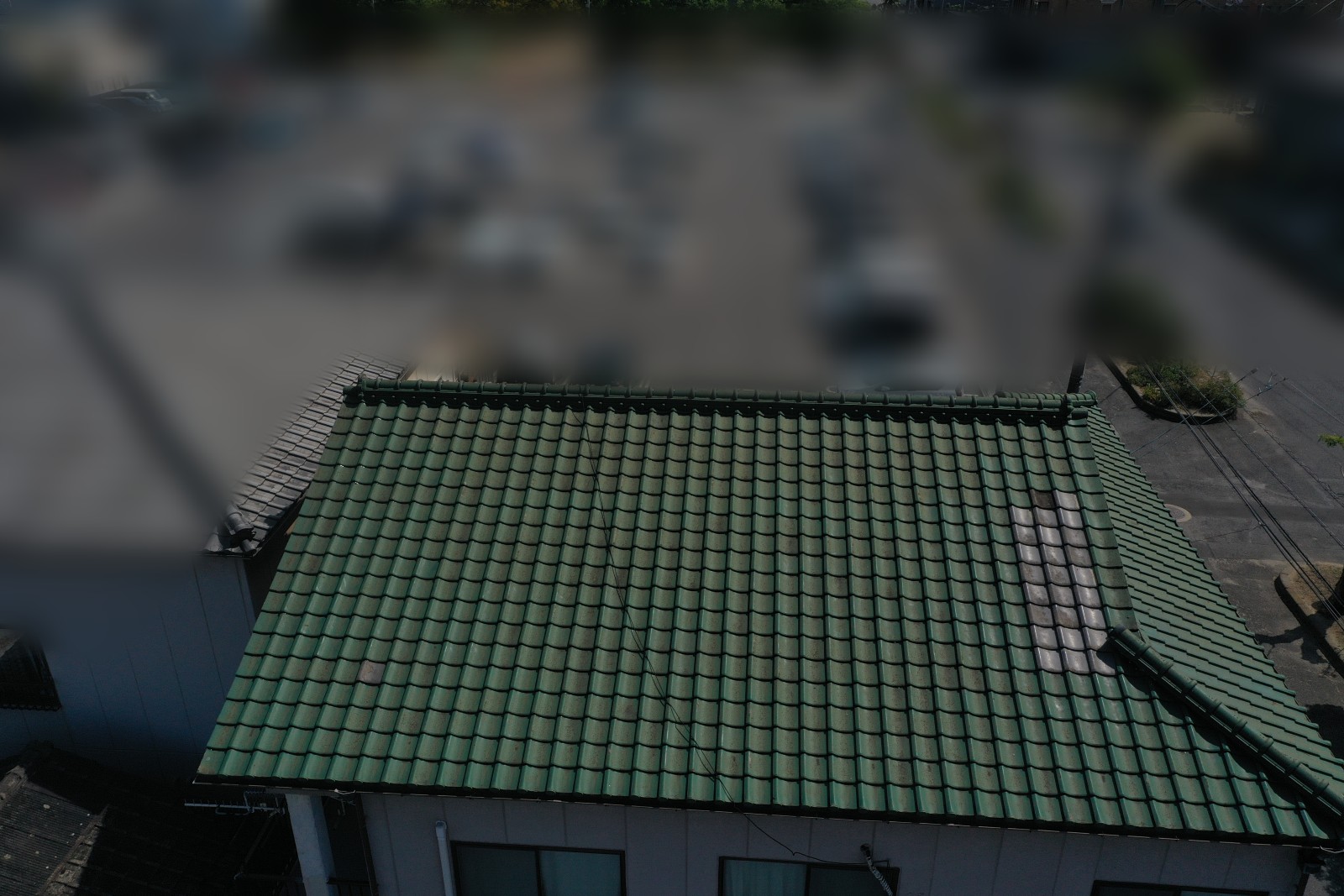 緑のセメント瓦の屋根全体の中で葺き直した所