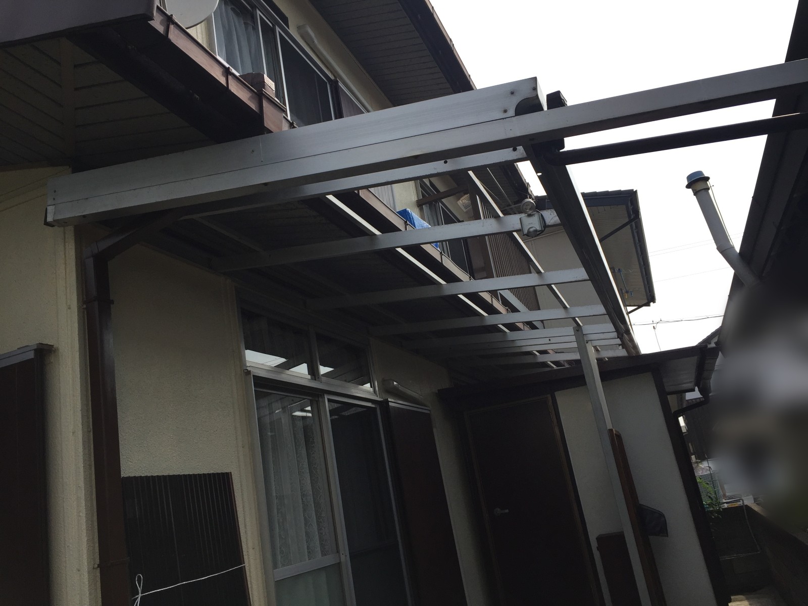 テラス屋根の骨組み付近で足場を組み立てる様子