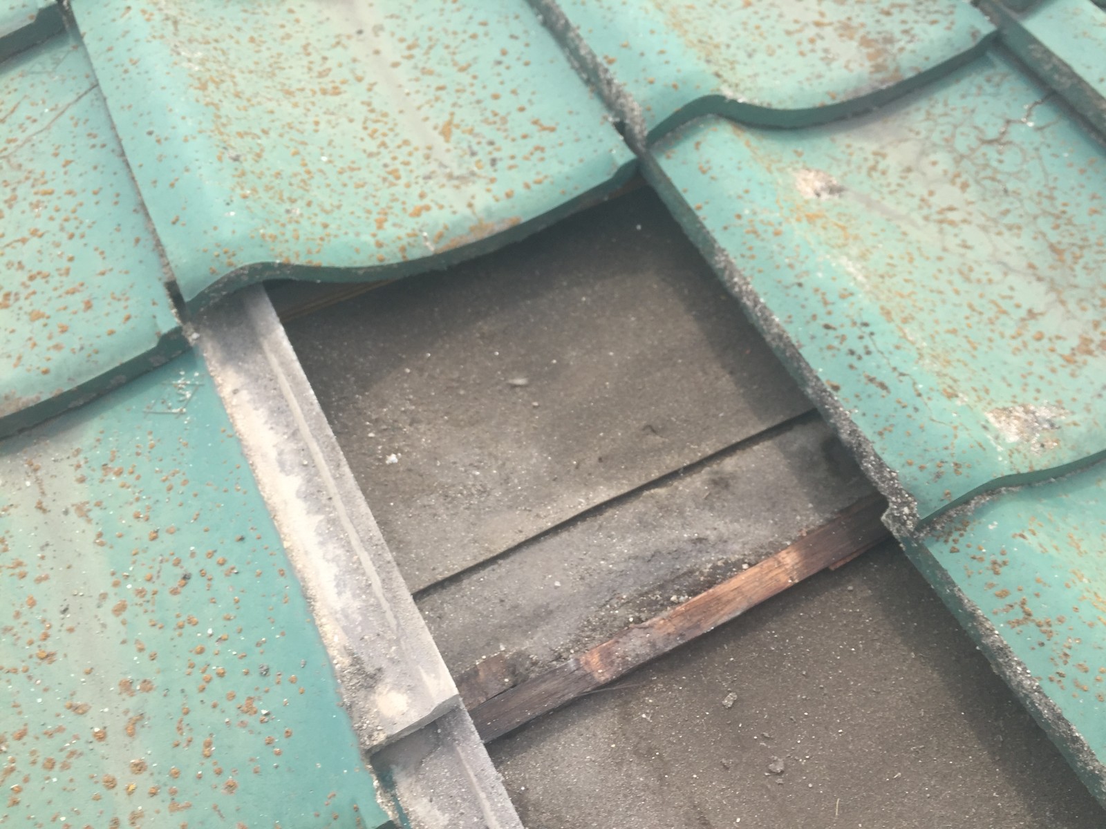 瓦をめくった所に見える水の入った跡と折れた瓦桟