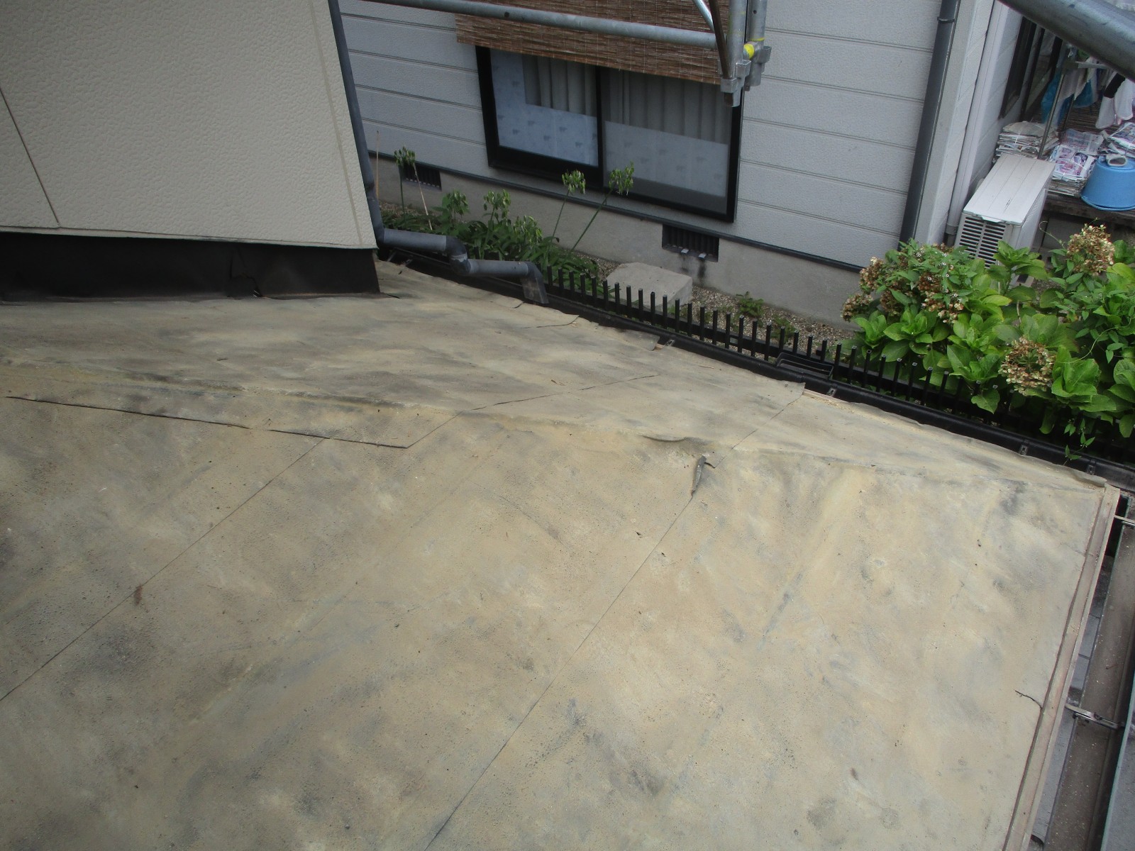 黒ずんだ古い防水紙が張られた屋根の下地