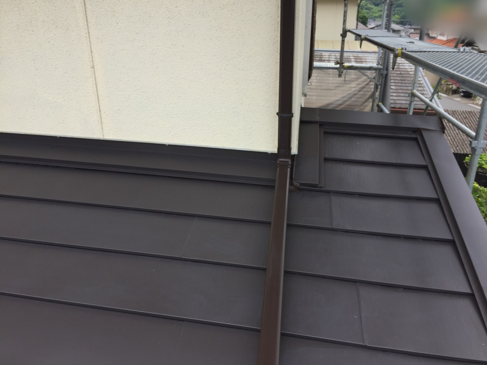 外壁の際まで仕上がった1階の屋根と新しく交換した竪樋