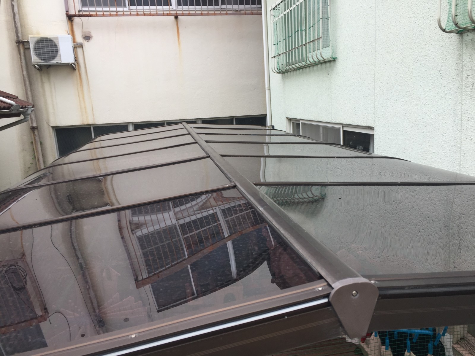 カーポート　ポリカーボネート　張り替え後　駐車場　押さえ材で固定した屋根端部