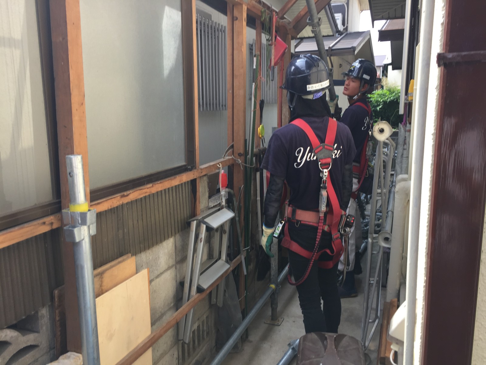 墜落制止用器具を使用して足場を組み立てる職人