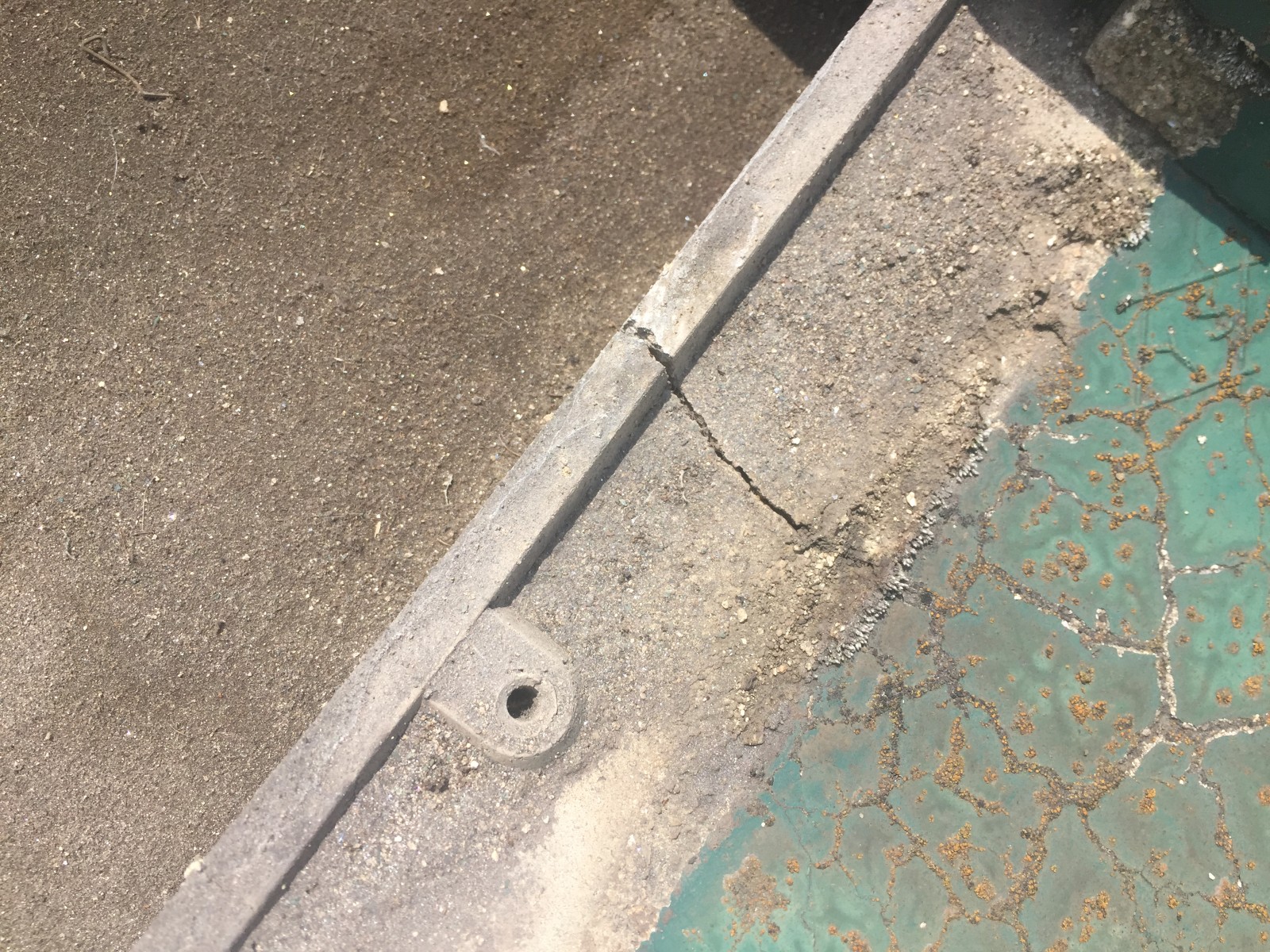 めくった瓦の裏に見えるひびと土ぼこり