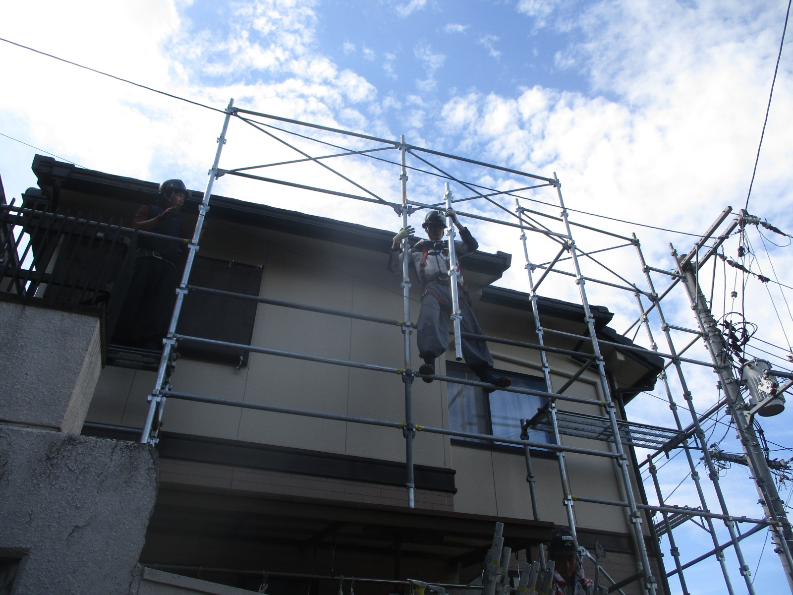 メッシュシートを外して見えてきた1階の新しい瓦屋根と足場