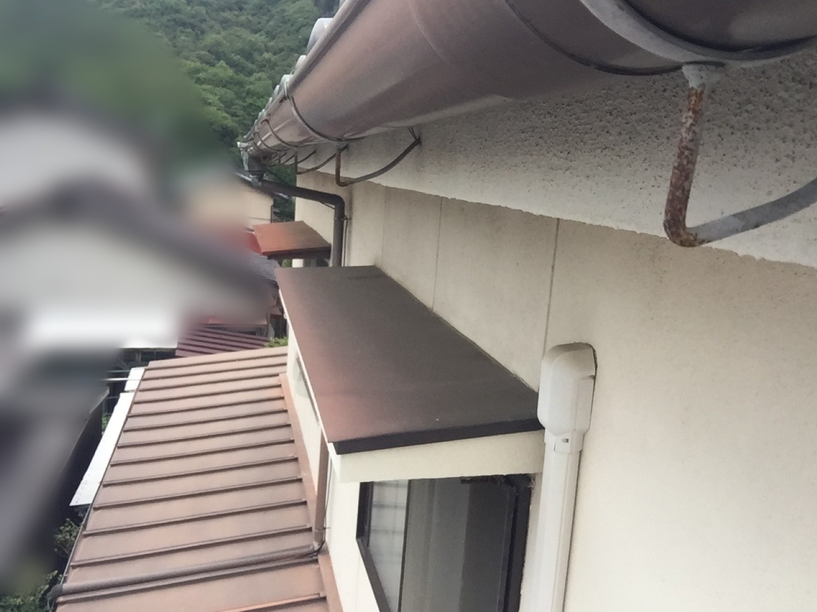 錆びて下に曲がった軒樋の吊り金具