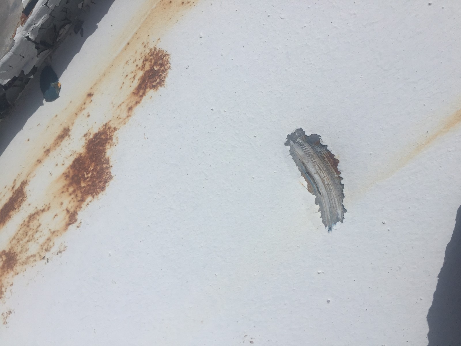 落ちた瓦が当たってできたとみられる金属の屋根の穴