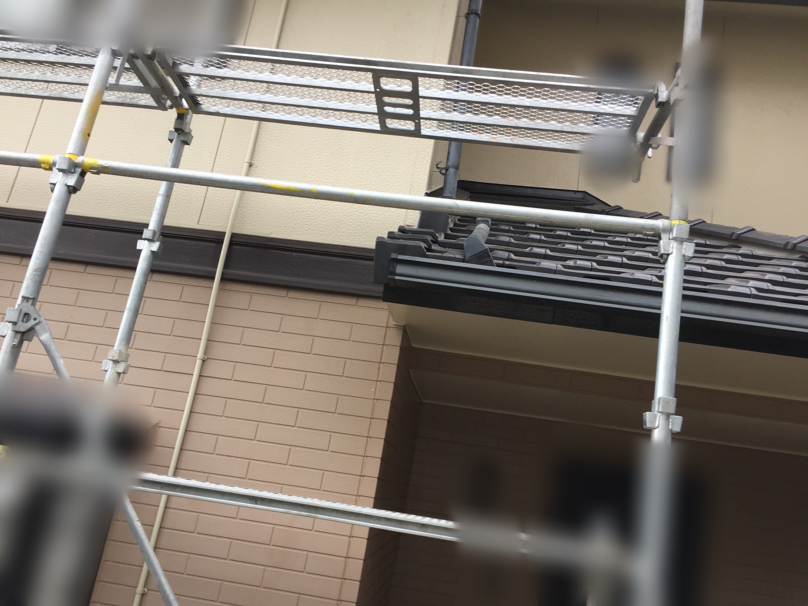 下の階の屋根をまたぐように組んだ足場の様子