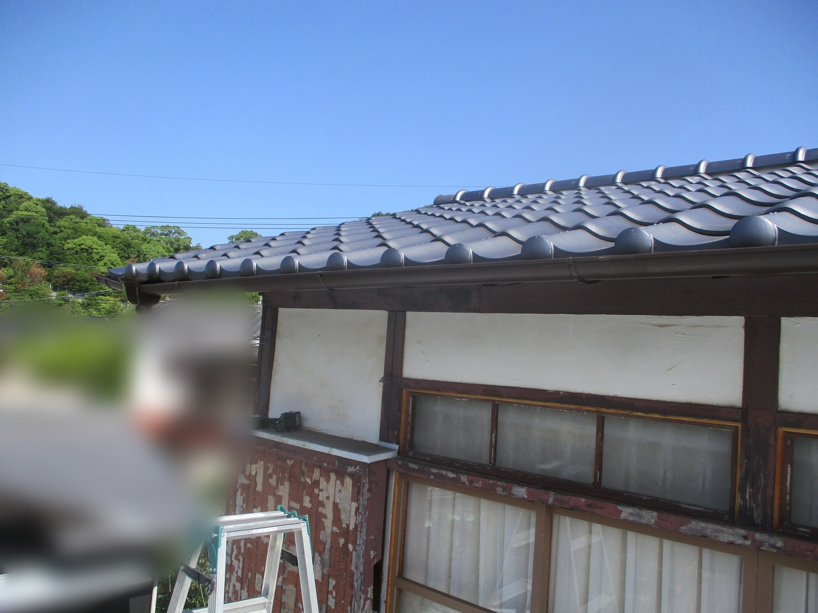 丸い瓦の先にそって取り付けた茶色の新しい雨樋