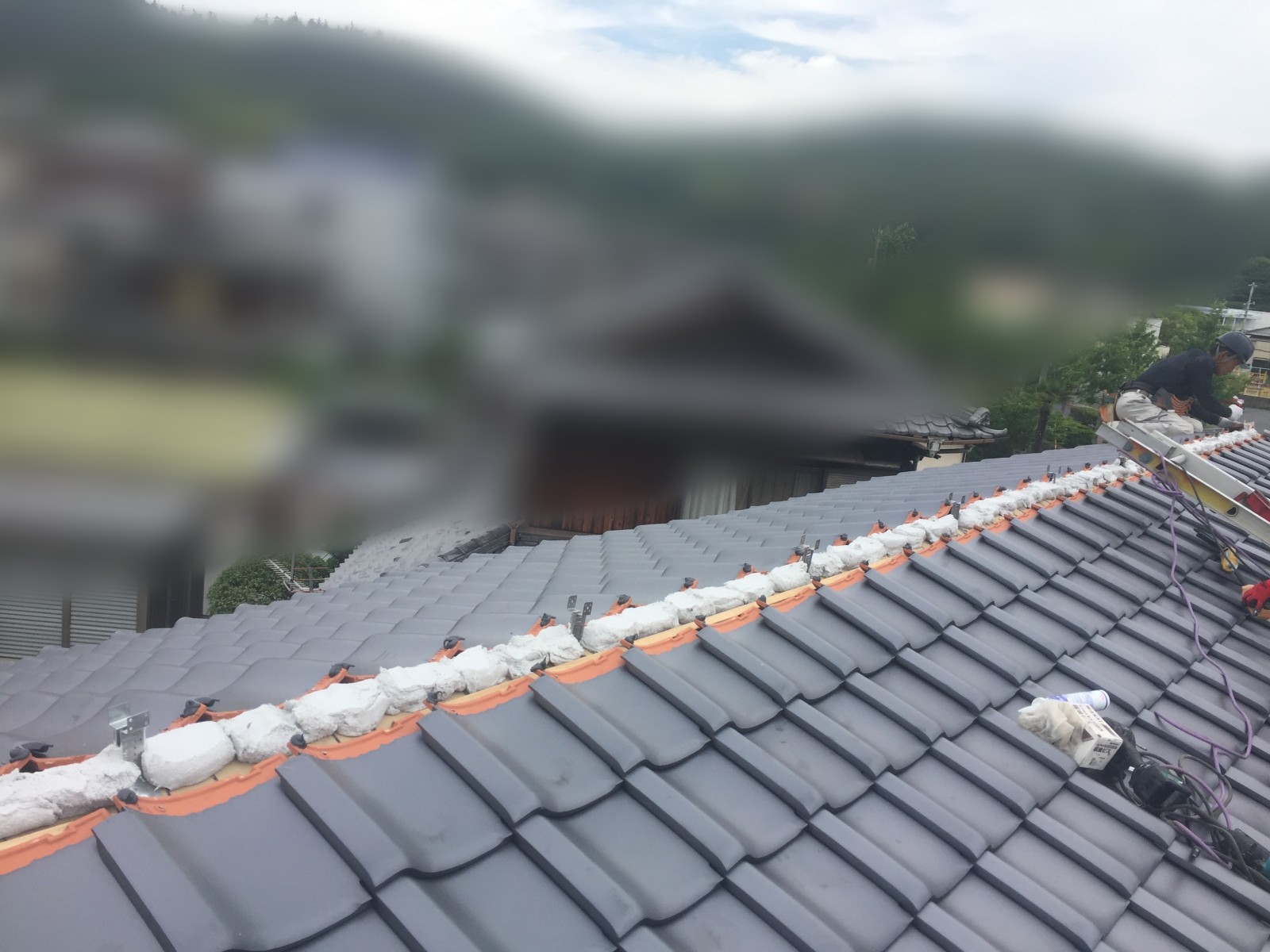 棟にそって白い土台が一直線に続く葺き替え中の屋根