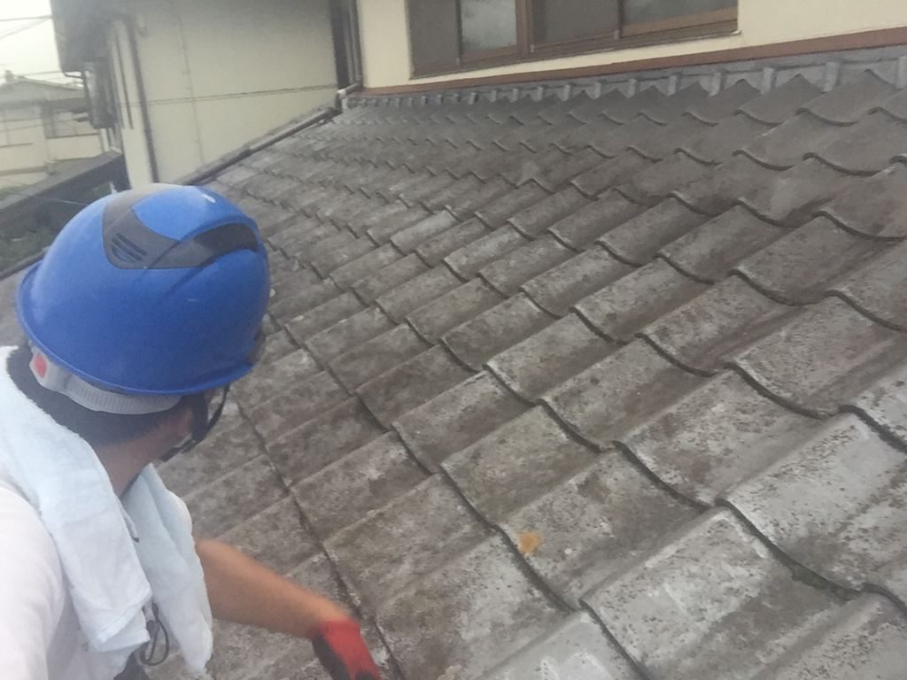 屋根に上がって瓦のズレや劣化、傷みを一枚ずつ確認する屋根点検