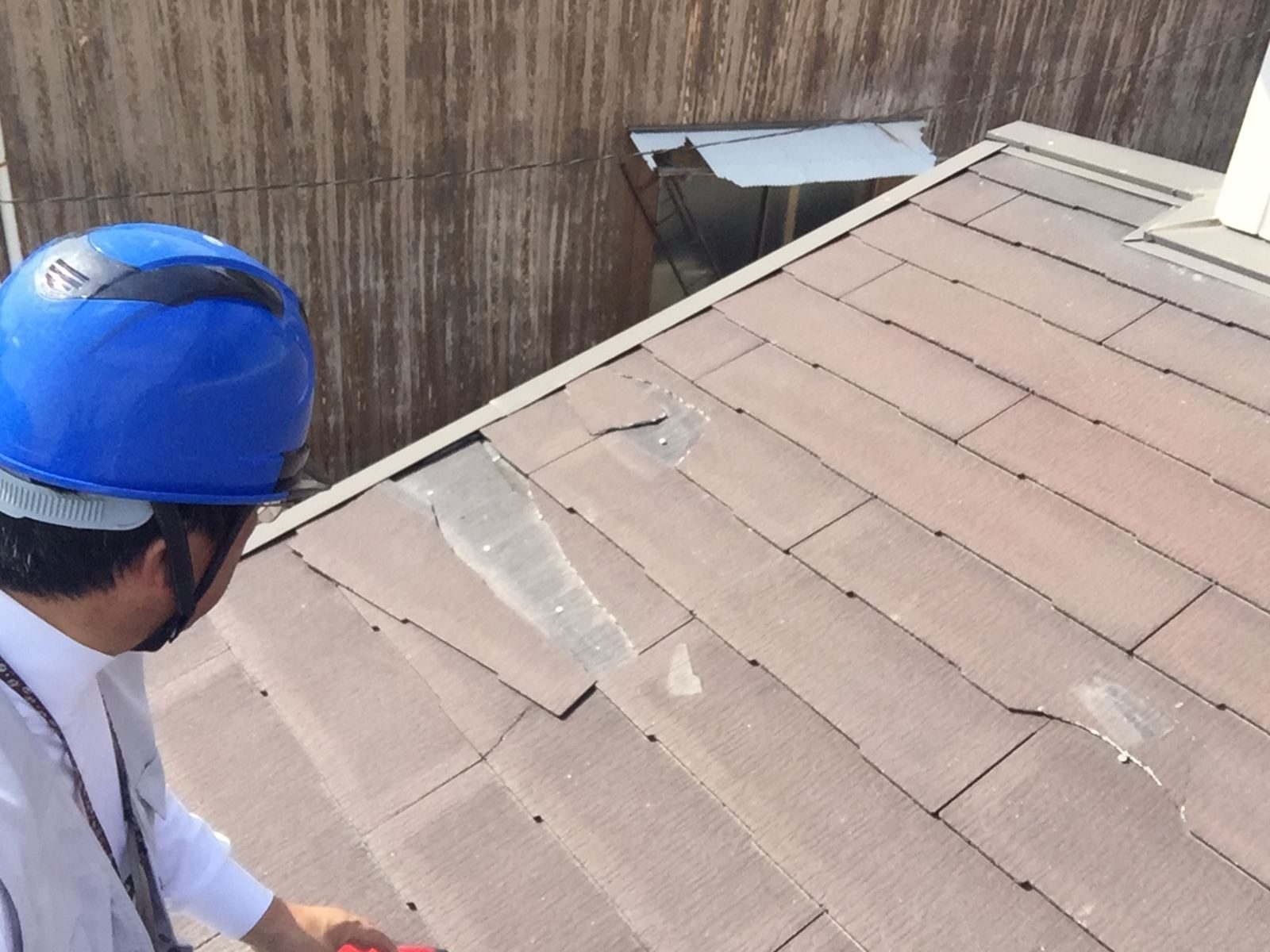 割れて一部がはがれ落ち、下地や留め釘が露出してしまっているスレート屋根
